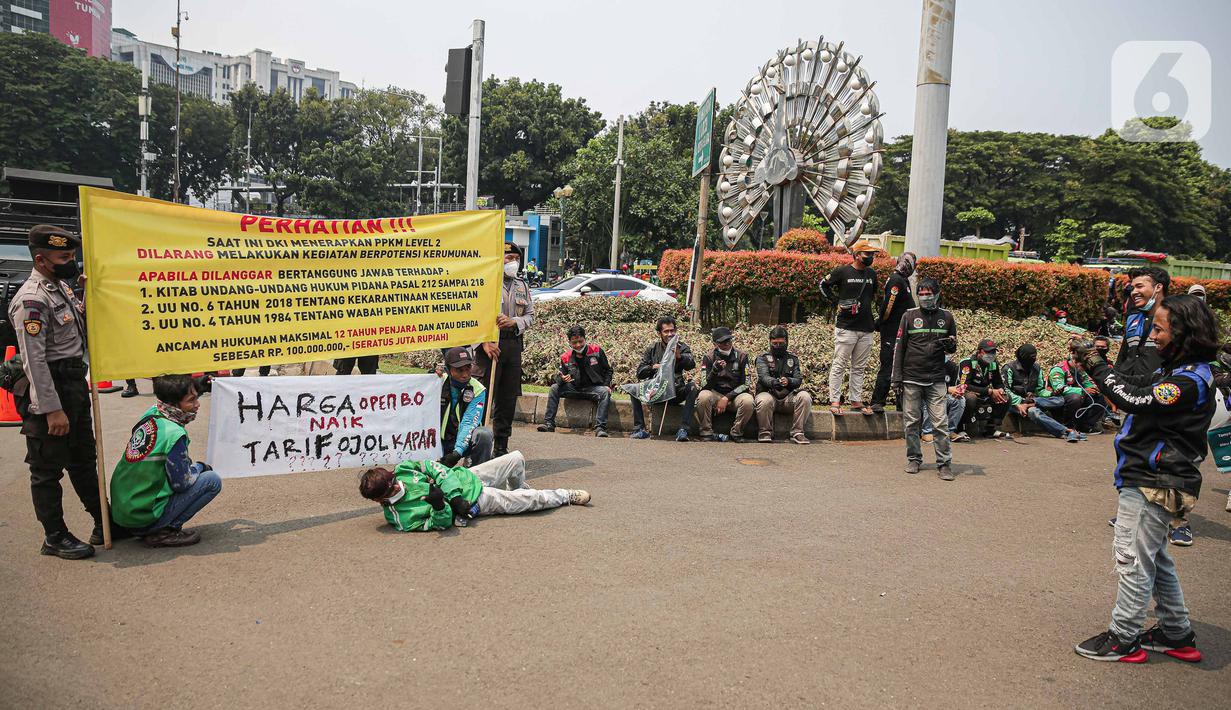 Sejumlah pengemudi ojek online melakukan aksi di kawasan Patung Kuda, Jakarta, Rabu (5/1/2022). Para pengemudi ojek online menuntut Kementerian Perhubungan serta pengelola aplikasi untuk menepati janji kenaikan tarif ojek online. (Liputan6.com/Faizal Fanani)