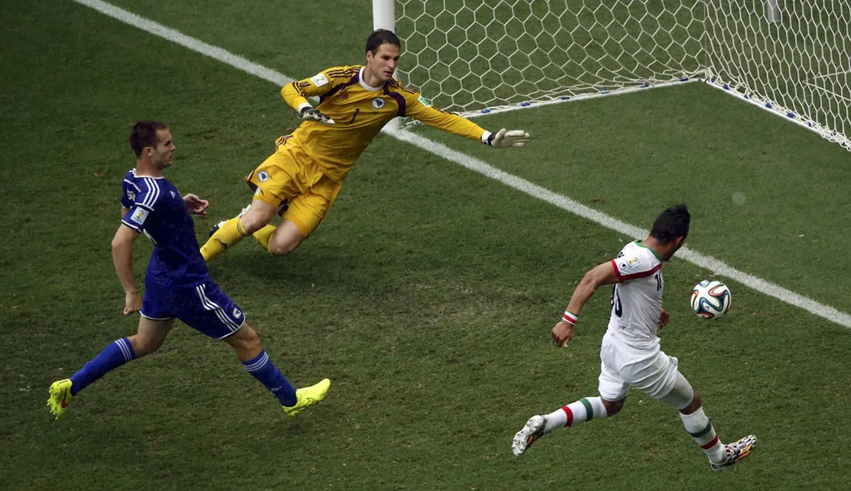 Pemain depan Iran, Reza Ghoochannejhad (kanan) saat berhasil menjebol gawang Bosnia di laga penyisihan terakhir Piala Dunia 2014 Grup F di Stadion Fonte Nova, Salvador, Brasil, (25/6/2014). (REUTERS/Fabrizio Bensch)