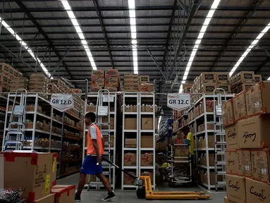 Pekerja melintas di antara rak barang di gudang milik Lazada Online Shop, Jakarta, Jumat (9/12). Hari Belanja Online Nasional yang jatuh pada 12 Desember 2016 dimanfaatkan situs belanja online untuk menarik pembeli. (Liputan6.com/Johan Tallo)