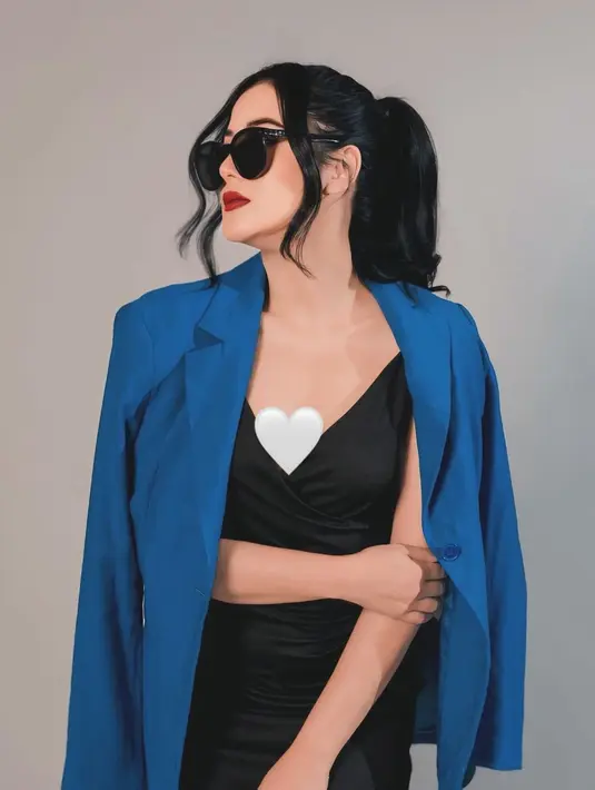 Pakai dress hitam dan blazer biru dongker yang menutupi pundaknya, Fera Feriska tampak berkelas. Rambut Fera ditata dengan gaya ponytail dengan poni kiri dan kanan. Kacamata hitam yang dikenakannya mendukung penampilannya jadi makin menarik dalam pemotretan ini. Berpose menghadap ke samping, Fera Feriska perlihatkan hidung dan proporsi wajahnya yang tampak sempurna. (Liputan6.com/IG/@_feraferiska_)