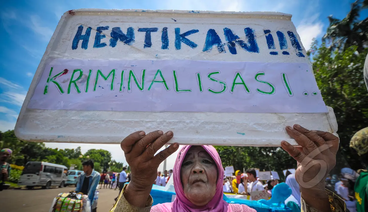 Seorang nenek membawa tulisan ‘Hentikan Kriminalisasi’ saat melakukan aksi Karnaval Rakyat Lawan Korupsi dari patung kuda menuju Istana Negara, Jakarta, Rabu (8/4/2015). (Liputan6.com/Faizal Fanani)