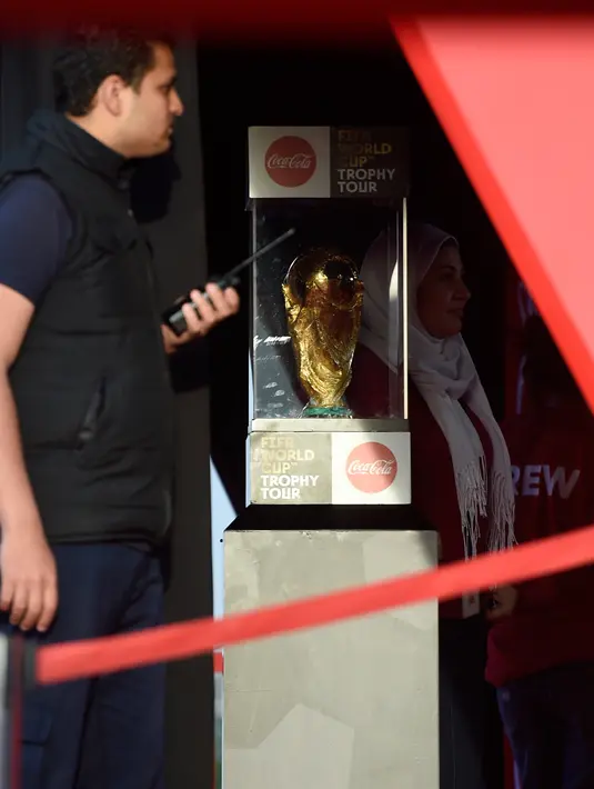 Petugas berjaga di samping trofi Piala Dunia FIFA  saat tur Dunia di Ibu Kota Kairo, Mesir (15/3).  Piala Dunia 2018 akan berlangsung pada bulan Juni di Rusia. (AFP Photo/Khaled Desouki)