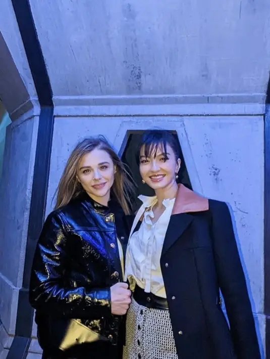 Masih di Korea Selatan dan acara yang sama, Raline kali ini mengenakan jaket panjang hitam berkerah coklat dipadukan inner kemeja putih dan mini skirt bermotif serta boots heels coklat nya. Ia pun bertemu dengan Chloe Grace Moretz.  Credit:  (@ralineshah)