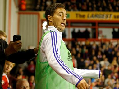 Pemain Chelsea, Eden Hazard, terkejut saat ditarik oleh seorang fan yang ingin berfoto saat Chelsea melawan Walsall dalam putaran ketiga Piala Liga Inggris di Stadion Banks, Inggris, Rabu (23/9/2015). (Action Images via Reuters/Carl Recine)