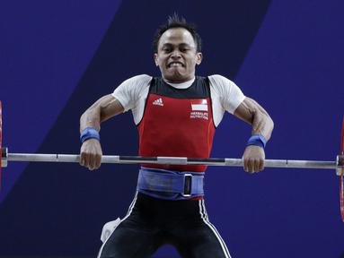 Lifter Suratman melakukan angkatan saat SEA Games 2019 cabang angkat besi nomor 55 kg di Stadion Rizal Memorial, Manila, Minggu (1/12). Dirinya meraih perak dengan total angkatan 250 kg. (Bola.com/M Iqbal Ichsan)