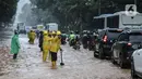 Petugas mengatur lalu lintas saat air menggenangi Jalan Medan Merdeka Barat, Jakarta, Kamis (24/1/2020). Hujan deras yang mengguyur Jakarta sejak pagi tadi mengakibatkan genangan air di Jalan Medan Merdeka Barat. (Liputan6.com/Faizal Fanani)