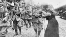 Prajurit Prusia yang meninggalkan Berlin diberi bunga oleh seorang wanita selama Perang Dunia I. Perang Dunia I membuka jalan untuk berbagai perubahan politik seperti revolusi di beberapa negara yang terlibat. (AP Photo, File)