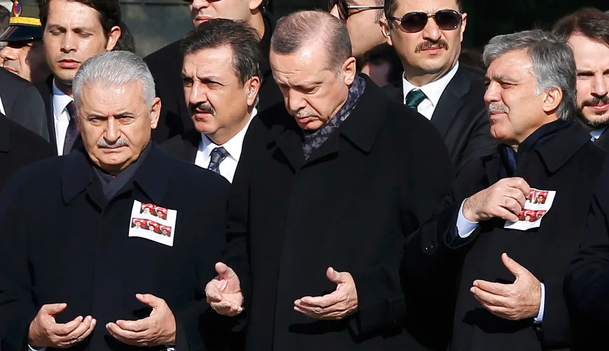 Presiden Turki, Tayyip Erdogan (tengah) berdoa bersama ratusan pelayat lain saat upacara pemakaman anggota Polisi yang tewas dalam ledakan bom di Istanbul, Turki (11/12). (Reuters/Murad Sezer)