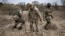 Anggota regu penjinak bom berjalan di ladang ranjau dekat Brovary, timur laut Kiev, di tengah invasi militer Rusia pada 14 April 202. Rusia sudah menarik tentara mereka dari Kiev dan mengalihkan sebagian besar fokus perangnya ke wilayah Ukraina timur pada akhir Maret. (FADEL SENNA/AFP)