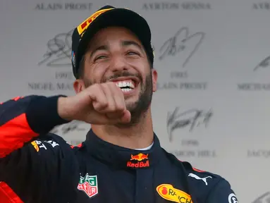 Pembalap Red Bull, Daniel Ricciardo mereyakan kemenangannya di atas podium usai menjuarai balapan GP Azerbaijan di Baku, Minggu (25/6). Kemenangan itu sekaligus menandai kesuksesan pertamanya meraih puncak pertama musim ini. (AP Photo/Darko Bandic)