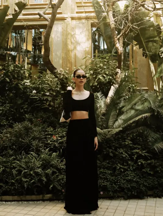 Dalam momen liburan ini, Alyssa tampil chic dengan cropped long sleeve top hitam yang dipadukan dengan maxi skirt senada. Shoulder bag putih, kacamata hitam, dan aksesori berupa anting emas menjadi pelengkap sempurna untuk menyempurnakan gaya high fashion ala jet-setter. Nuansa old money begitu terasa dalam setiap detail yang ia kenakan. [@alghazali7].