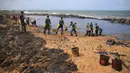 Tentara Sri Lanka bahu membahu membersihkan tumpahan minyak di sebuah pantai di Uswetakeiyawa, Kolombo, Senin (10/9). Jumlah minyak yang tumpah diperkirakan sekitar 25 ton. (AP Photo/Eranga Jayawardena)