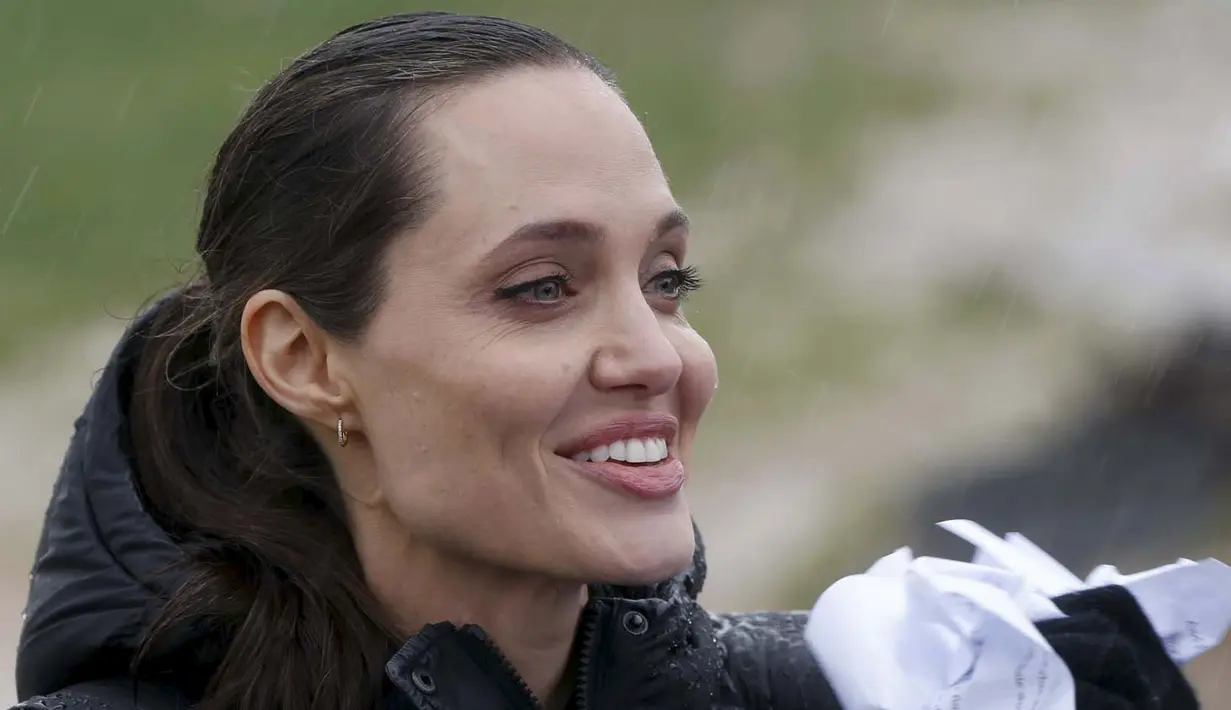 Angeline Jolie saat berkunjung ke tempat pengungsian warga Suriah di Lebanon, Selasa (15/3). Angelina Jolie juga menyempatkan diri untuk melakukan konferensi pers meski hujan mengguyur lokasi pengungsi.(Reuters/Mohamed Azakir)