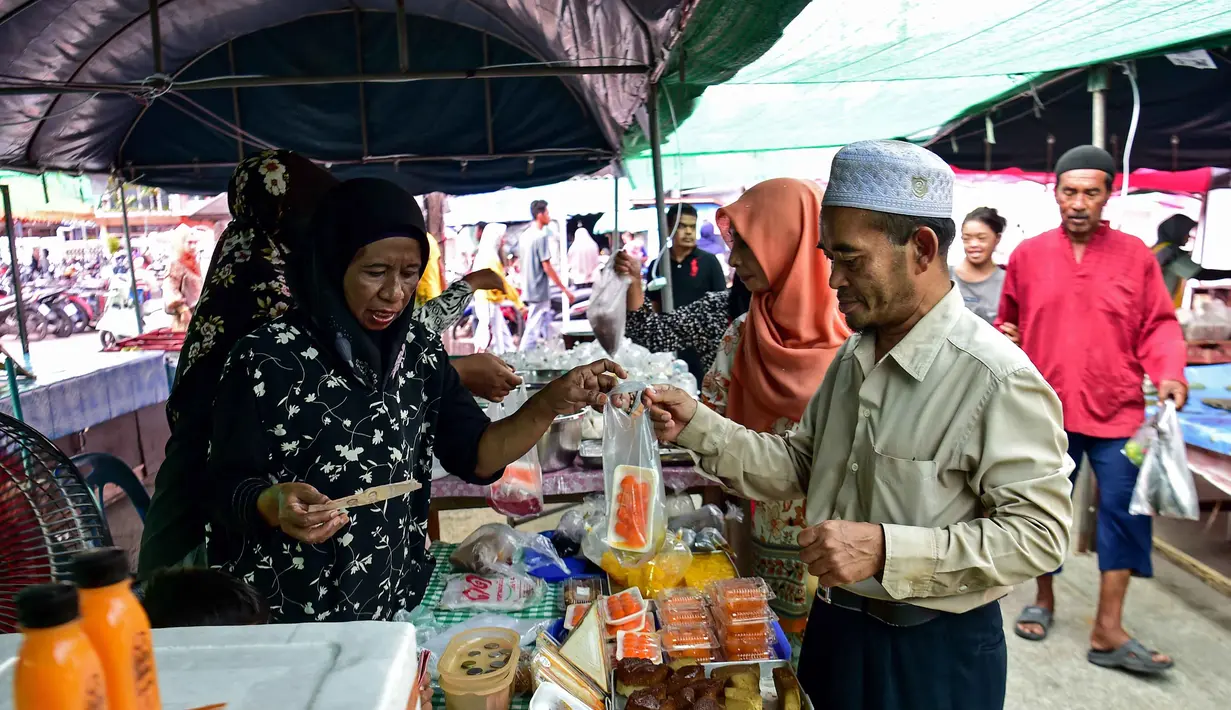 Beragam penganan dan kudapan dijajakan di sejumlah pasar di sekitar jalan-jalan utama kota Narathiwat yang menjadi pusat perburuan menu makanan untuk berbuka puasa bagi warga lokal. Tampak dalam foto, orang-orang membeli makanan untuk berbuka puasa pada hari pertama bulan suci Ramadan 1447 Hijriah di sebuah pasar di provinsi Narathiwat, Thailand selatan, pada Kamis 19 Februari 2026. (Madaree TOHLALA/AFP)