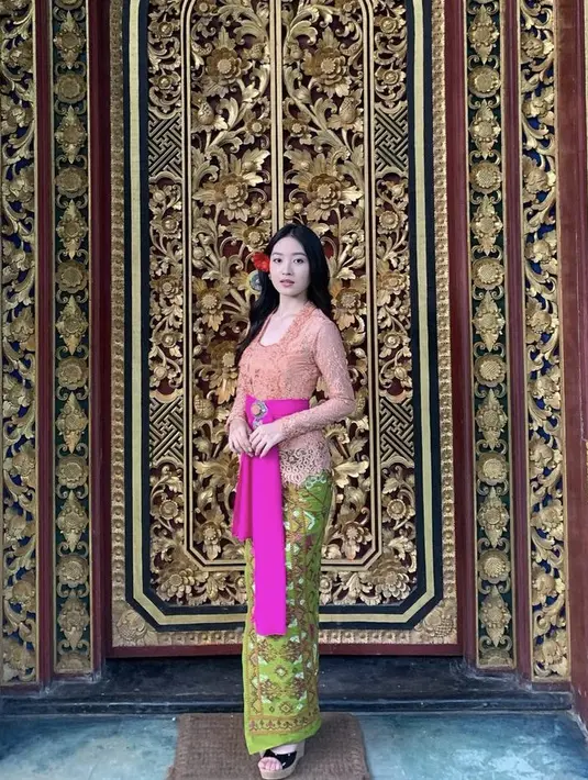 Natasha Wilona pun tampil anggun dengan kebaya peach khas Bali lengkap dengan belt fushcia dan kain lilit hijaunya. Credit: Instagram (@natashawilona12)
