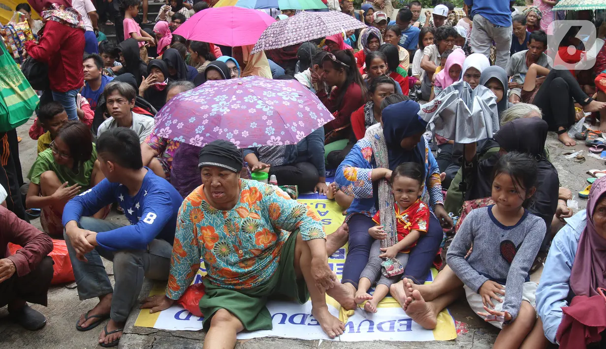Pengemis menunggu sedekah Imlek di halaman Vihara Dharma Bhakti, Petak Sembilan, Jakarta Barat, Sabtu (25/1/2020). Pembagian sedekah tersebut dalam rangka berbagi dengan sesama ketika perayaaan Tahun Baru Imlek 2571. (Liputan6.com/Angga Yuniar)