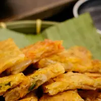Ilustrasi Tempe Mendoan/Photo by Richard L: https://www.pexels.com/photo/crispy-fried-tempeh-on-banana-leaf-plate-32432716/