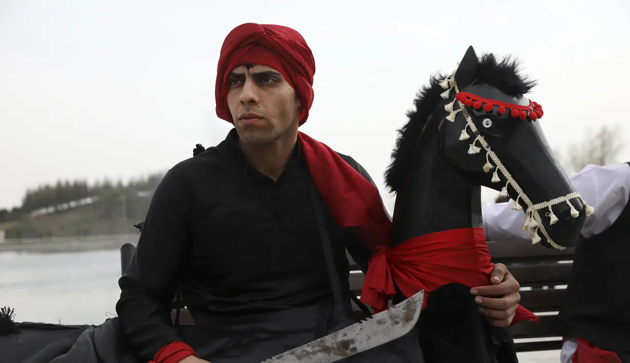 Seorang pemain cerita rakyat dari wilayah timur Iran menunggu perannya dalam upacara menjelang Tahun Baru Iran, atau Nowruz, di sebuah taman di Teheran, Iran (14/3/2022). (AP Photo/Vahid Salemi)