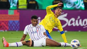 Pemain Al-Nassr, Cristiano Ronaldo, berusaha melewati pemain Al-Ain, Saeed Juma, di Liga Champions Asia 2023/2024 di Al-Awal Park Stadium, Selasa (12/3/2024). (AFP/Fayez Nureldine)
