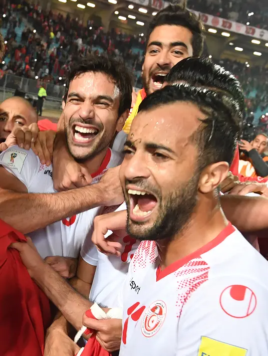 Pemain Timnas Tunisia melakukan selebrasi usai pertandingan melawan Libya dan dinyatakan lolos ke Piala Dunia 2018 di Stadion Olimpiade Rades, Tunisia (11/11). (AFP Photo/Fethi Belaid)