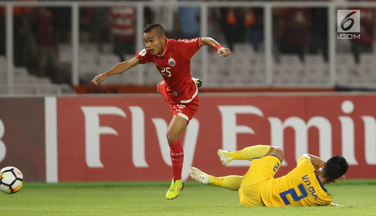 Gelandang Persija, Riko Simanjuntak melompat menghindari tekel pemain Song Lam Nghe An pada fase grup H Piala AFC di Stadion GBK Jakarta, Rabu (14/3). Babak pertama Persija ditahan imbang Soang Lam Nghe An 0-0. (Liputan6.com/Helmi Fithriansyah)