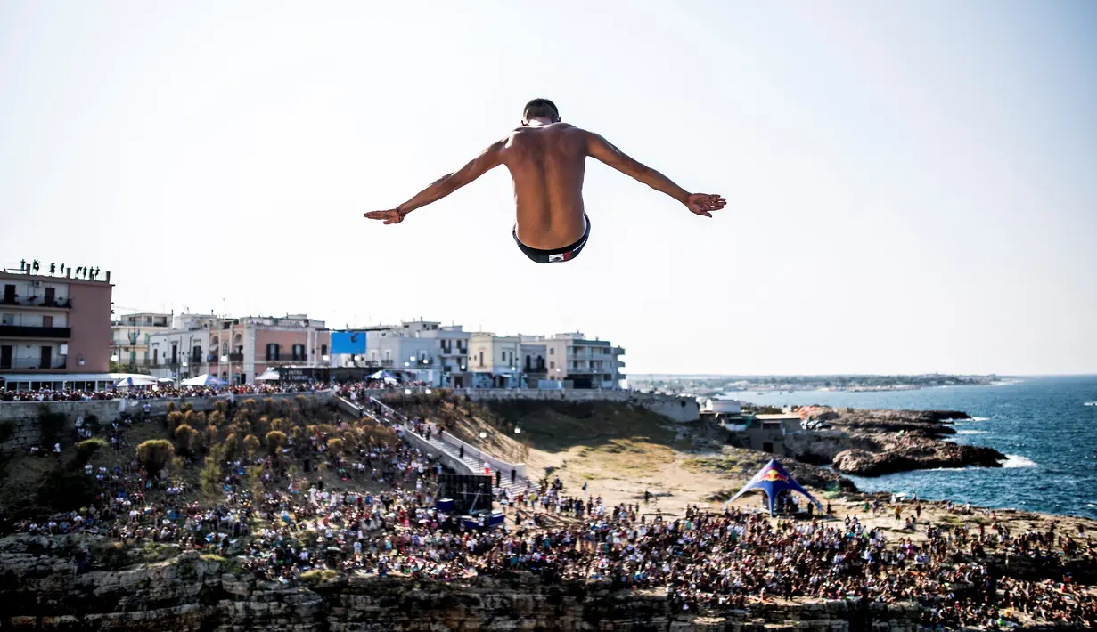  Atlet Meksiko, Jonathan Paredes, melakukan lompatan dari ketinggian 27 meter dalam kejuaraan loncat indah Red Bull Cliff Diving World Series di Polignano a Mare, Italia, (AFP/Dean Treml/Red Bull)