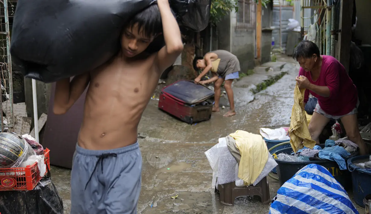 Warga mulai membersihkan rumah mereka saat banjir yang disebabkan oleh Badai Tropis Yagi, yang secara lokal disebut Enteng, mereda di kota Antipolo, provinsi Rizal, Filipina, Selasa (3/9/2024). (AP Photo/Aaron Favila)