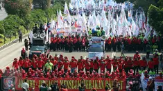 Massa buruh dan pekerja dari berbagai daerah mulai memadati Jalan MH Thamrin, Jakarta, dalam peringatan May Day, Senin (1/5). Mereka mengibarkan bendera organisasi buruh dan membentangkan spanduk di sepanjang perjalanan. (Liputan6.com/Johan Tallo)