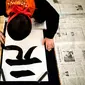 Seorang peserta menulis kaligrafi Jepang selama kontes kaligrafi untuk merayakan tahun baru di Tokyo, Sabtu (5/1). Ajang yang dalam bahasa Jepang disebut kakizome ini dianggap sebuah peruntungan. (Behrouz MEHRI / AFP)