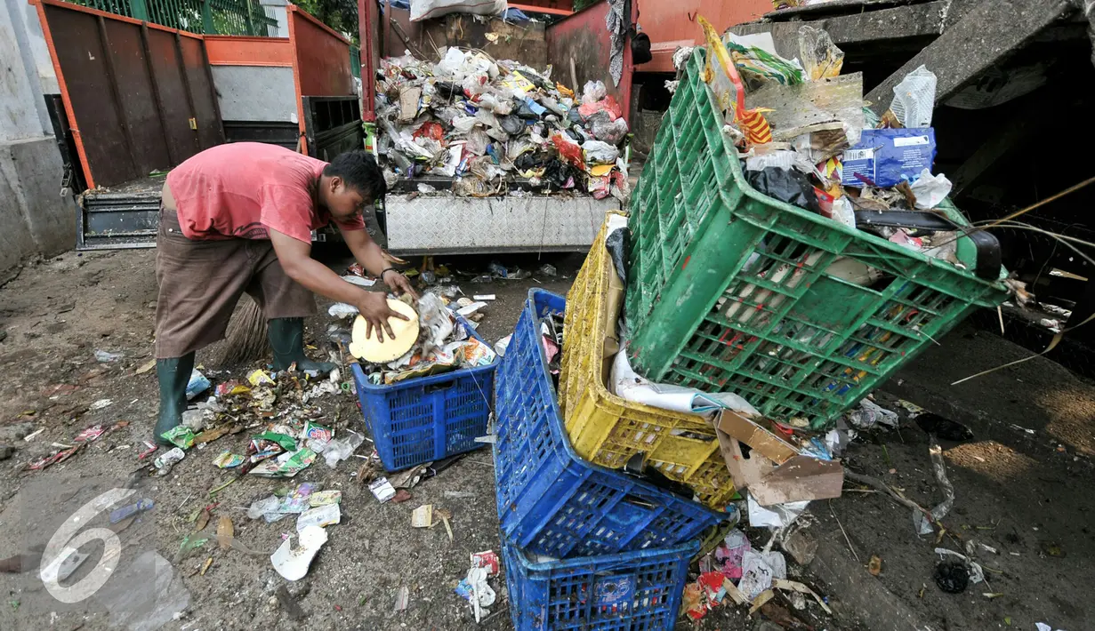 Pekerja membersihkan sampah yang tercecer saat dipindahkan, Jakarta, Senin (11/7). Pasca libur Lebaran, volume sampah di Kecamatan Jagakarsa diperkirakan mencapai 200 ton. (Liputan6.com/Yoppy Renato)