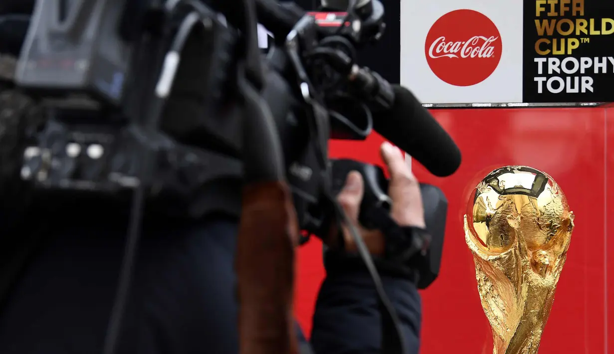 Seorang jurnalis mengambil gambar trofi FIFA World Cup saat FIFA World Cup Trophy Tour di Paris (20/3). Piala Dunia 2018 diselenggarakan 14 Juni dan 15 Juli 2018 di Rusia. (AFP Photo/Franck Fife)
