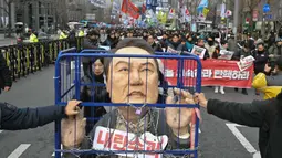 Dalam aksinya, para pengunjuk rasa juga membawa poster bergambar Presiden Yoon Suk Yeol yang terborgol dan terpenjara. (ANTHONY WALLACE/AFP)