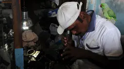 Joseph Sekar saat memperbaiki kamera di Chennai, India, Jumat (17/3). Pekerjaan sehari-hari Joseph Sekar adalah menerima jasa perbaikan kamera. (AFP PHOTO / ARUN Sankar)