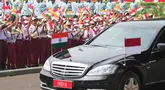 Anak-anak sekolah melambaikan bendera nasional Indonesia dan India saat iring-iringan kendaraan yang membawa Perdana Menteri India Narendra Modi melintas selama upacara penyambutan menjelang pertemuan Modi dengan Presiden Prabowo Subianto di Istana Merdeka di Jakarta,  Selasa, 7 Juli 2026. (AP Photo/Achmad Ibrahim)