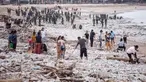 Para pekerja dan warga membersihkan ceceran dan tumpukan sampah plastik yang terdampar di Pantai Jimbaran, Bali, pada Selasa 10 Maret 2026. Pantai Jimbaran, Bali, kembali dipenuhi sampah kiriman. (Lana Priatna/AFP)