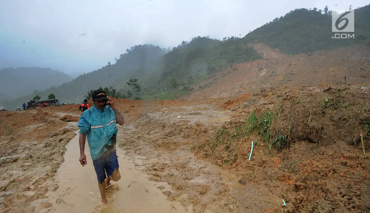 Warga melintas di atas perkampungan yang tertimbun longsor di Dusun Cimapag, Desa Sirnaresmi, Kecamatan Cisolok, Sukabumi, Selasa (1/1). BNPB mencatat, sebanyak 41 orang diduga masih tertimbun longsoran. (merdeka.com/Arie Basuki)
