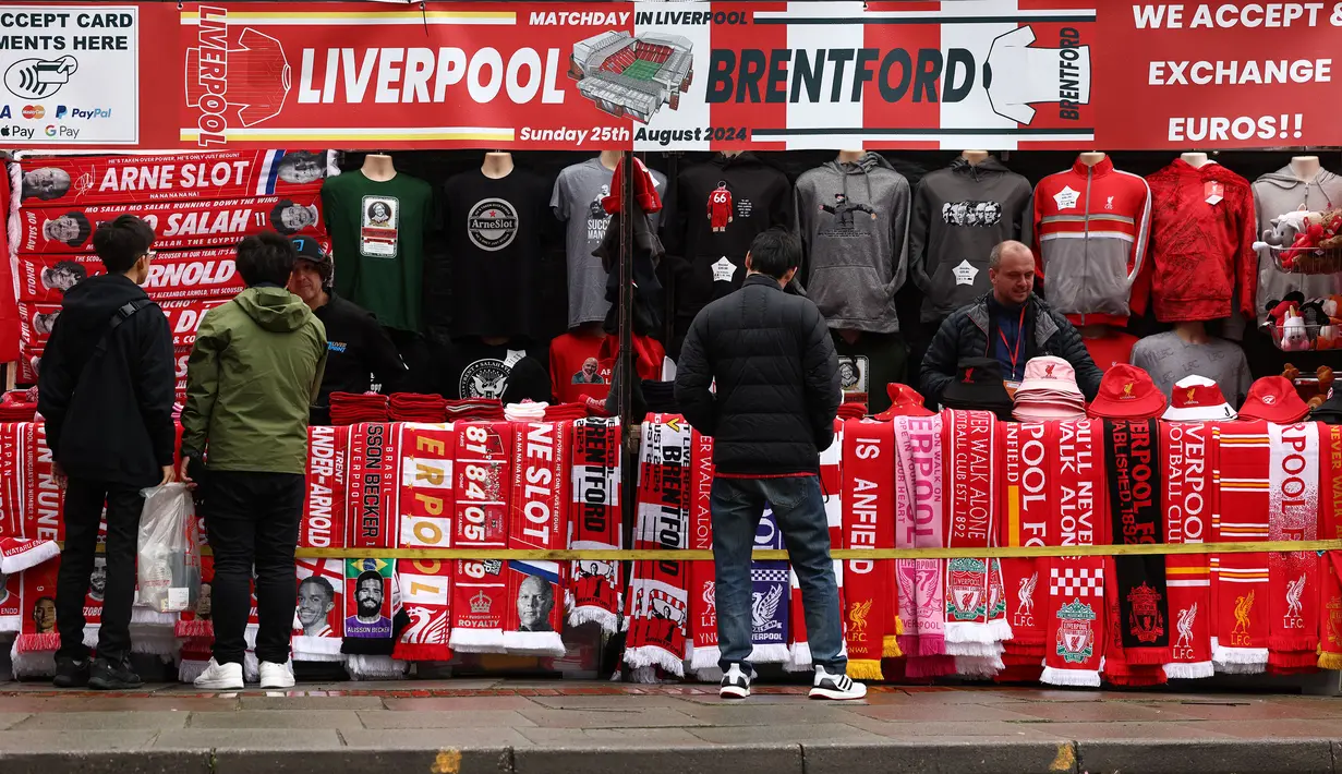 Pendukung Liverpool tengah berbelanja di toko merchandise sebelum laga lanjutan Liga Inggris 2024/2025 melawan Brentford di Anfield, Liverpool, Inggris, Minggu (25/08/2024) malam WIB. (AFP/Darren Stapless)