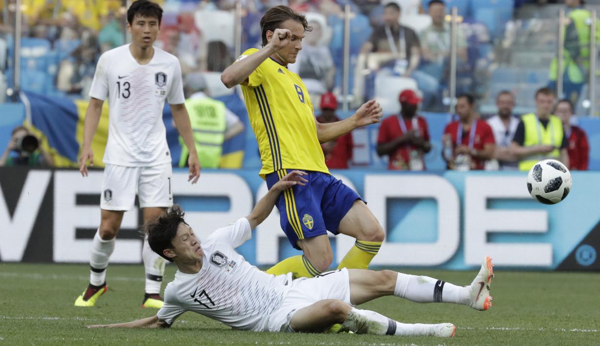 Pemain Korea Selatan, Lee Jae-sung  menghalau bola dari kaki pemain Swedia, Albin Ekdal pada laga grup E Piala Dunia 2018 di Nizhny Novgorod stadium, Nizhny Novgorod, Rusia, (18/6/2018). Swedia menang 1-0. (AP/Lee Jin-man)