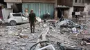 Seorang pria Palestina berdiri di tengah reruntuhan bangunan tempat tinggal dan mobil yang rusak setelah serangan Israel di Kota Gaza pada Kamis 4 Juni 2026. (Omar AL-QATTAA/AFP)