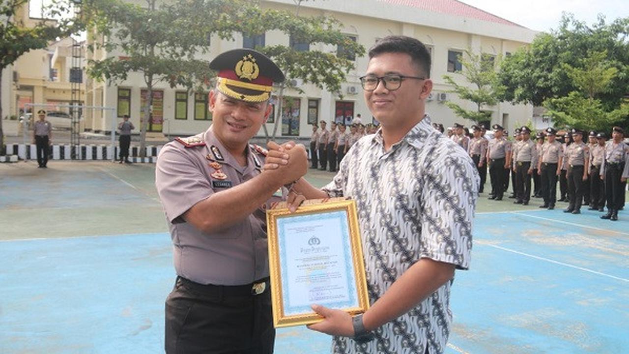 Kapolres Karanganyar, AKBP Leganek Mawardi, (kiri), menyerahkan penghargaan kepada warga Desa Ngringo, Kecamatan Jaten, Muhammad Syahrial Muchtar, (kanan), di Mapolres Karanganyar