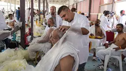 Jemaah haji mencukur rambut kepala atau tahalul usai melaksanakan lempar jumrah, Mina, Arab Saudi, Minggu (11/8/2019). Tahalul adalah kegiatan mencukur rambut setelah kegiatan ibadah haji. (FETHI BELAID/AFP)