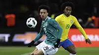 Gelandang Brasil, Willian, berebut bola dengan gelandang Jerman, Leroy Sane, pada laga persahabatan di Stadion Olympiastadion, Berlin, Selasa (27/3/2018). Jerman takluk 0-1 dari Brasil. (AP/Michael Sohn)