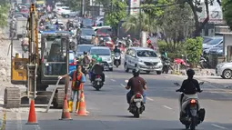Kondisi lalu lintas saat pekerja menyelesaikan proyek revitalisasi trotoar di kawasan Kemang, Jakarta, Jumat (29/6/2019). Kepala Dinas Binamarga DKI Jakarta mengatakan anggaran pembenahan trotoar Kemang dan Jalan Prof Doktor Satrio Jakarta Selatan capai Rp 100 miliar. (Liputan6.com/Herman Zakharia)