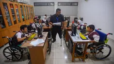 Pagi menjelang siang, suasana senyap menyelimuti ruangan kelas komputer. Pak Agung (39 tahun) berjalan hilir mudik mengawasi murid-murid penyandang disabilitas yang sedang mengerjakan tugas desain visual dengan menggunakan aplikasi canva. (merdeka.com/Arie Basuki)