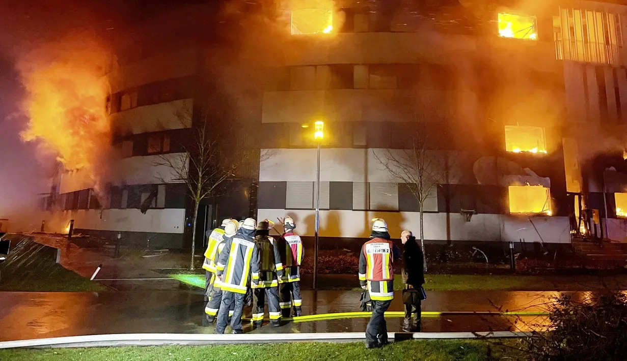 Petugas pemadam kebakaran memadamkan api di kompleks perumahan di Essen Jerman, Senin (21/2/2022). Penyebabnya belum diketahui, tetapi api tampaknya menyebar dengan cepat setelah terjadi pada dini hari, dipicu oleh hembusan angin. (Stephan Witte/KDF-TV/dpa via AP)