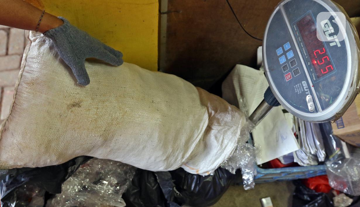 Petugas PPSU Kelurahan Kota Bambu Selatan menimbang sampah plastik di Bank Sampah Hasil Berkah, Jakarta, Kamis (11/11/2021). Sampah plastik dikonversi menjadi solar menggunakan alat mesin pirolisis untuk mengurangi pencemaran lingkungan. (Liputan6.com/Herman Zakharia)