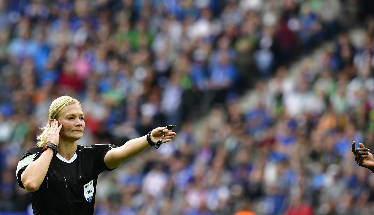 Aksi wasit wanita, Bibiana Steinhaus mendengar masukan asisten pelatih saat memimpin laga Bundesliga antara Hertha Berlin dan Werder Bremen di Berlin, Jerman (10/9/2017). Laga tersebut merupakan debut Bibiana Steinhaus. (AFP/Tobias Schwarz)