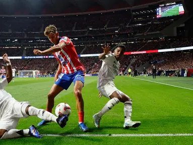 Gelandang Atletico Madrid, Marcos Llorente (tengah) berebut bola dengan penyerang Real Madrid, Endrick dan Rodrygo selama pertandingan Liga Spanyol di stadion Metropolitano, Madrid, Minggu 29 September 2024 atau Senin (30/9/2024) dini hari WIB. (OSCAR DEL POZO/AFP)