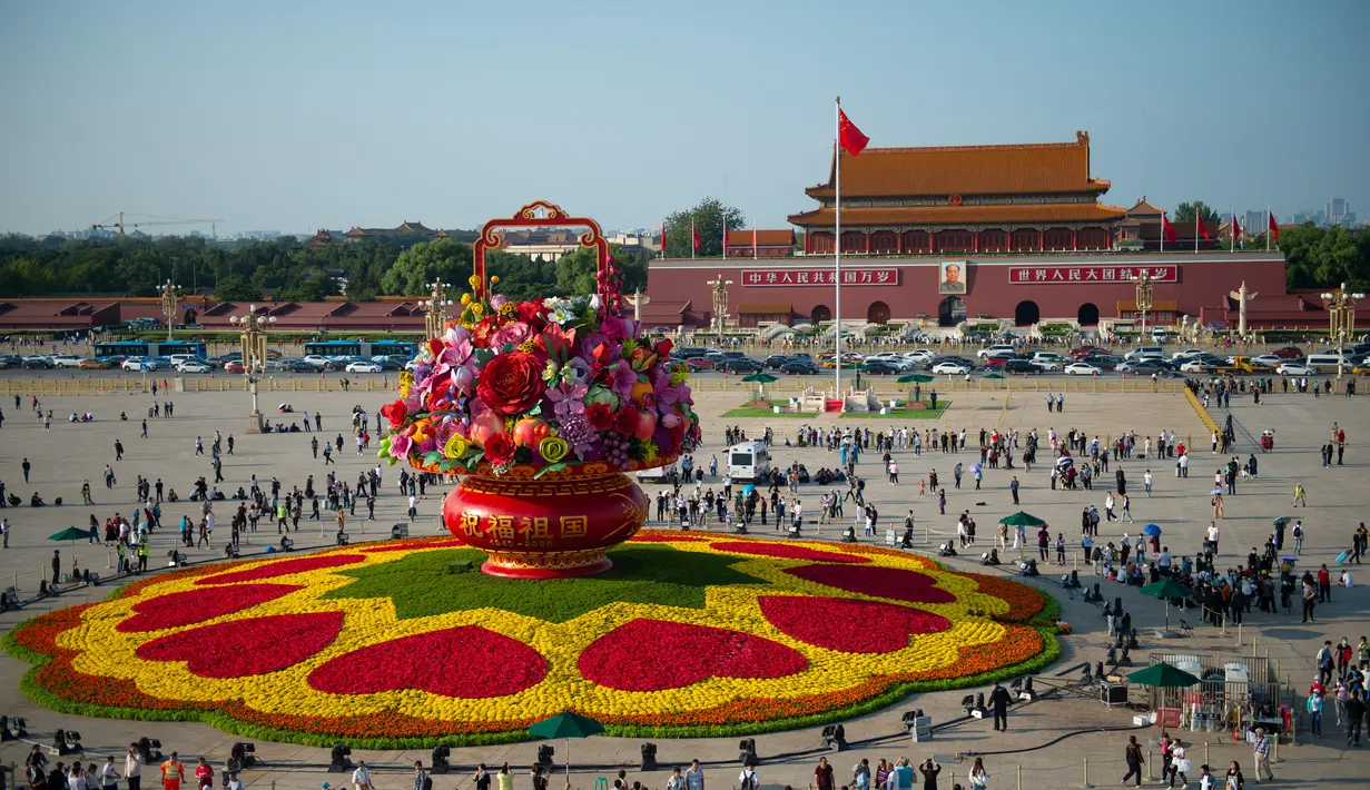 Para wisatawan berjalan di dekat "keranjang bunga" di Lapangan Tian'anmen di Beijing, ibu kota China (24/9/2020). Dekorasi setinggi 18 meter berbentuk keranjang bunga itu ditempatkan di tengah Lapangan Tian'anmen untuk menyambut masa libur Hari Nasional China mendatang. (Xinhua/Chen Zhonghao)