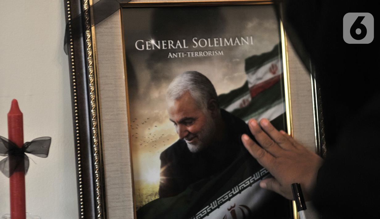 Warga mengusap foto Panglima Garda Revolusi Iran Jenderal Qasem Soleimani di Kedubes Iran, Jakarta, Selasa (7/1/2020). Kedubes Iran membuka kunjungan bagi warga Indonesia untuk mengucapkan belasungkawa atas kepergian Jenderal Qassim Sulaimani. (merdeka.com/Iqbal S. Nugroho)